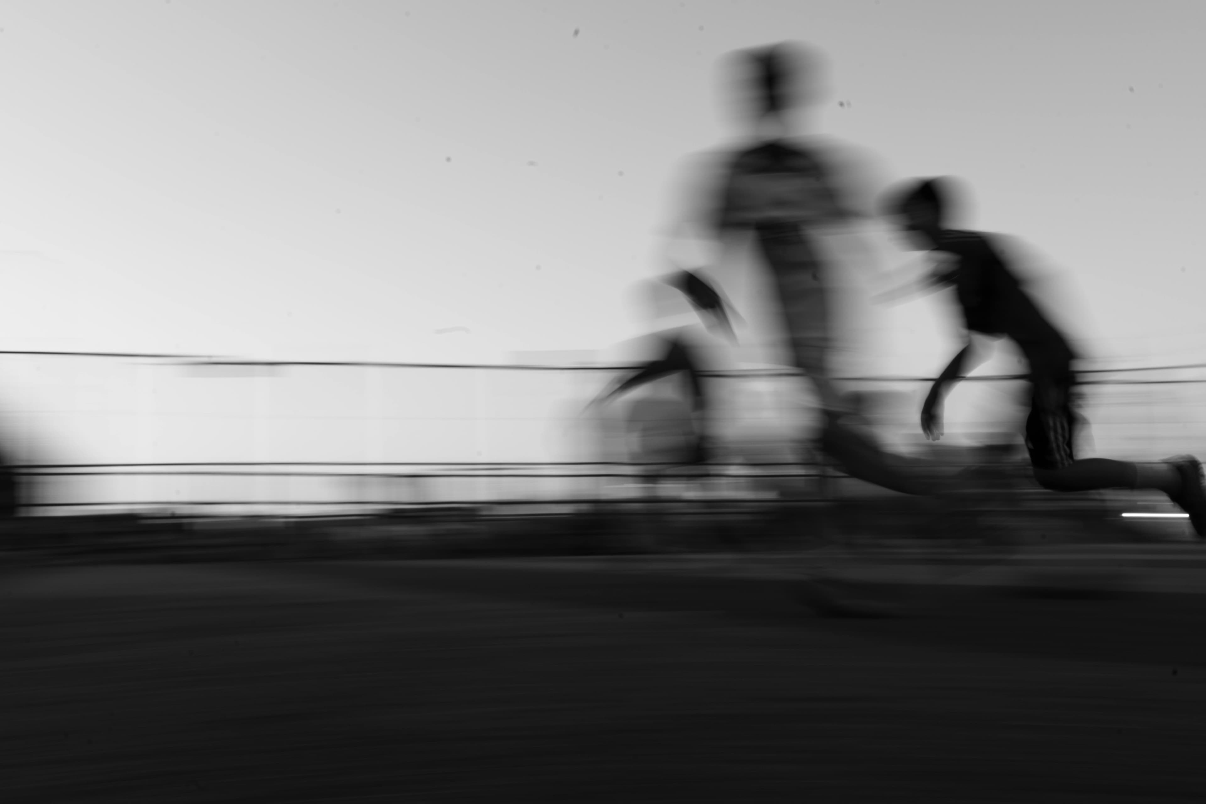 Photo dynamique en noir et blanc de coureurs en mouvement, transmettant la vitesse et le mouvement.