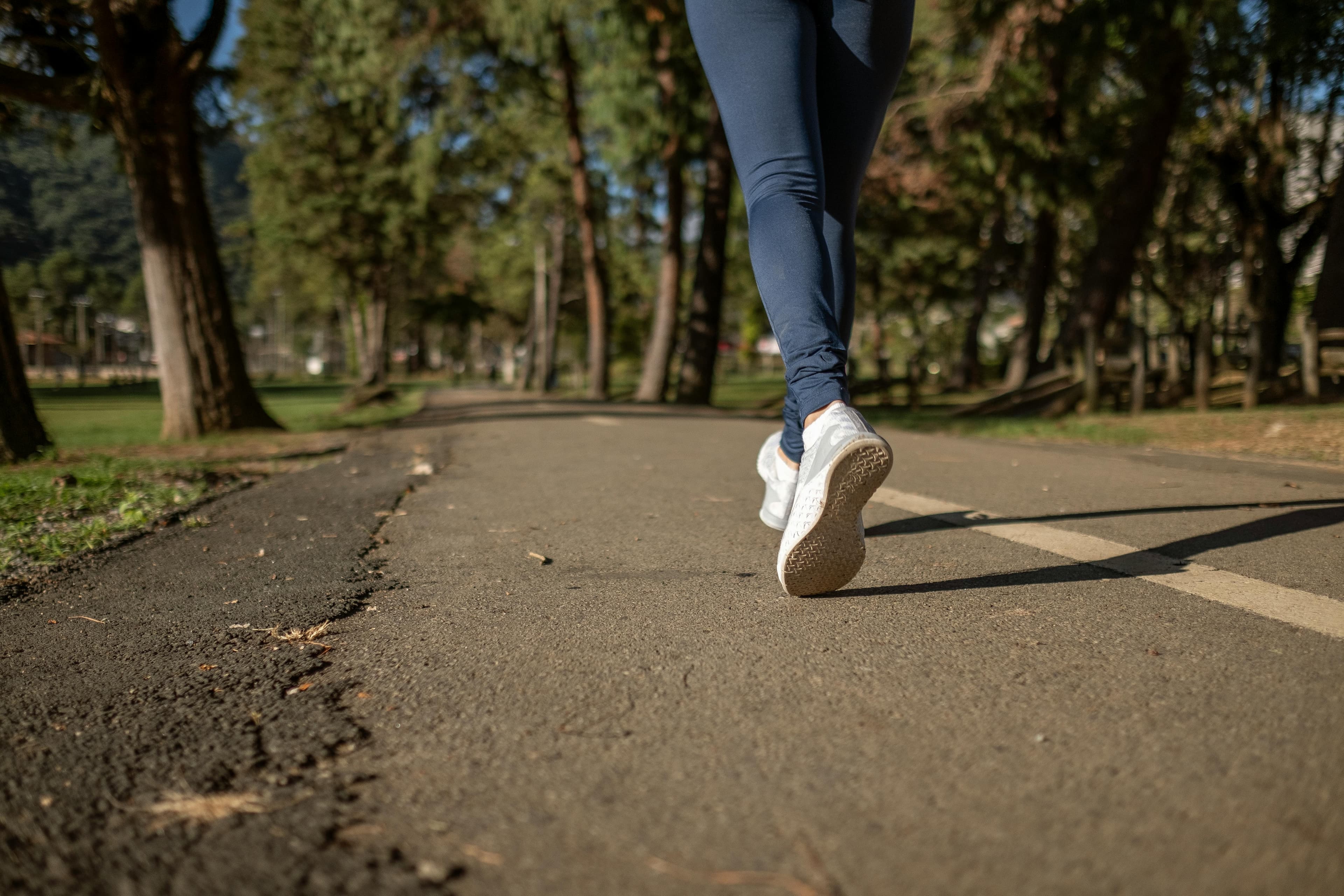 Persona En Blue Denim Jeans Y Zapatillas Blancas Caminando Por La Carretera